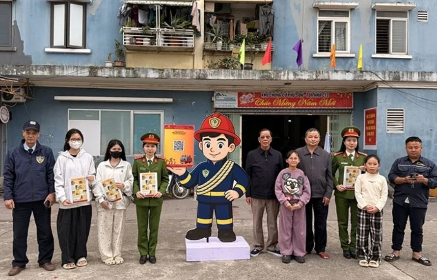 Cán bộ Phòng Cảnh sát PCCC&CNCH hướng dẫn người dân tại chung cư Phú Sơn, phường Hạc Thành qu&eacute;t mã QR để tìm hiểu kiến thức, kỹ năng an toàn về PCCC. Ảnh: Báo Thanh Hóa.