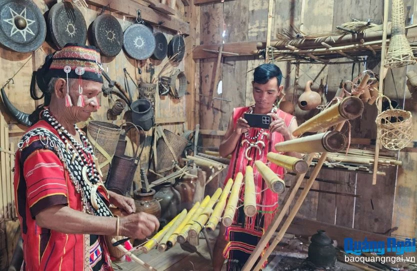 Anh Bloong Muôn (bên phải), ở thôn Đăk Răng, xã Dục Nông quay video ghi lại cảnh nghệ nhân A Vẻ sử dụng nhạc cụ dân tộc. Ảnh: Báo Quảng Ngãi.