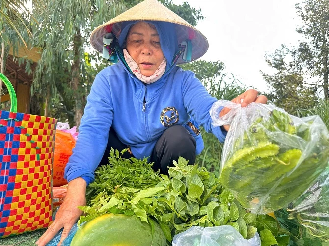 +ảnh 5: Bà Lê Thị Trúc Mai đang bán nông sản cho du khách tại chợ phiên Xóm Rẫy. (Ảnh: An Xuyên). +ảnh 5: Bà Lê Thị Trúc Mai đang bán nông sản cho du khách tại chợ phiên Xóm Rẫy. (Ảnh: An Xuyên).