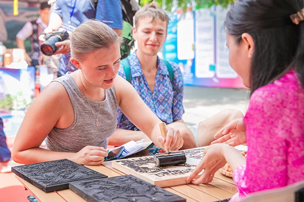 Du khách nước ngoài trải nghiệm sáng tạo tranh mộc bản về Đà Nẵng.