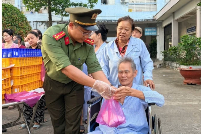 Ảnh 2- Đoàn viên thanh niên  Công an tỉnh An Giang và các tình nguyện viên trao suất ăn cho các bệnh nhân.