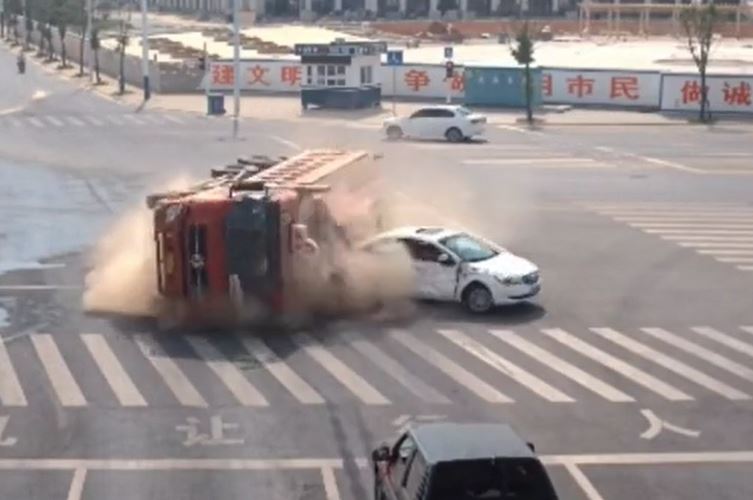 Xe tải chở đất lật ngang giữa ngã tư, suýt đè bẹp ô tô con