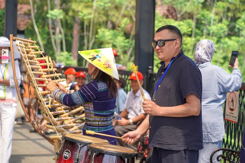 Du khách nước ngoài thích thú trải nghiệm nhạc cụ dân tộc tại Khi du lịch Thung lũng tình yêu.