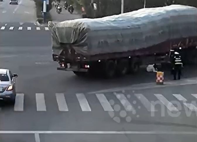 Cảnh sát lao tới kéo người phụ nữ khỏi gầm xe tải trong gang tấc