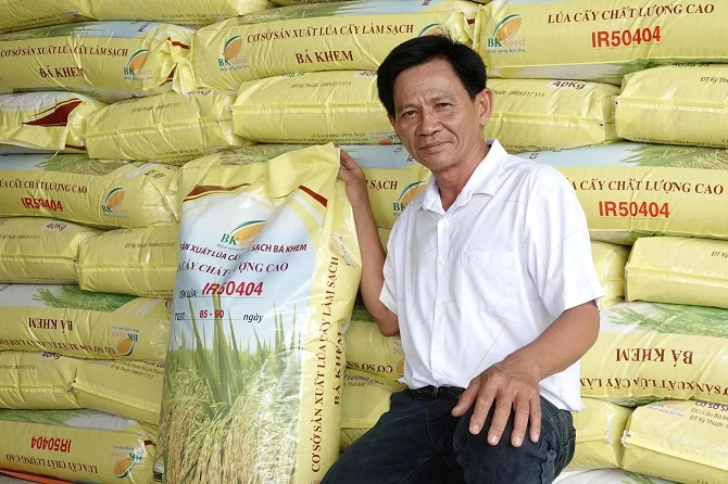 Ảnh 1: Ông Hồ Bá Phiêu bên những bao lúa giống.