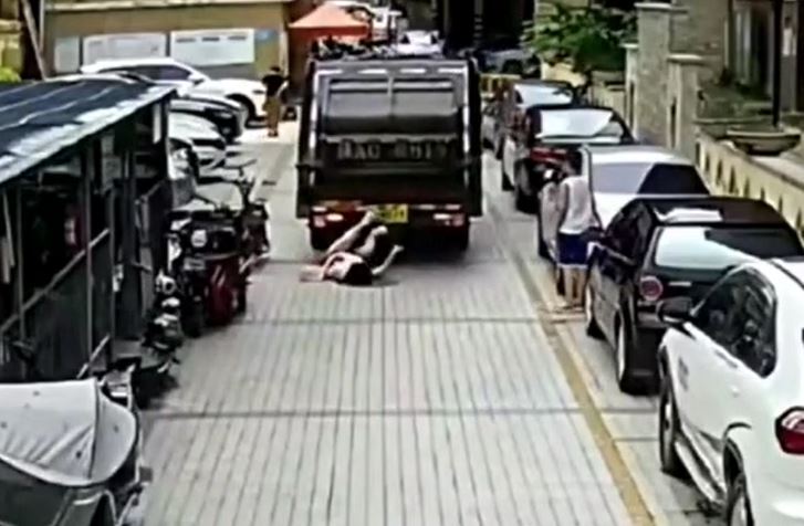 Mải nhìn điện thoại khi đi bộ, người phụ nữ bị xe chở rác tông ngã rồi cuốn vào gầm