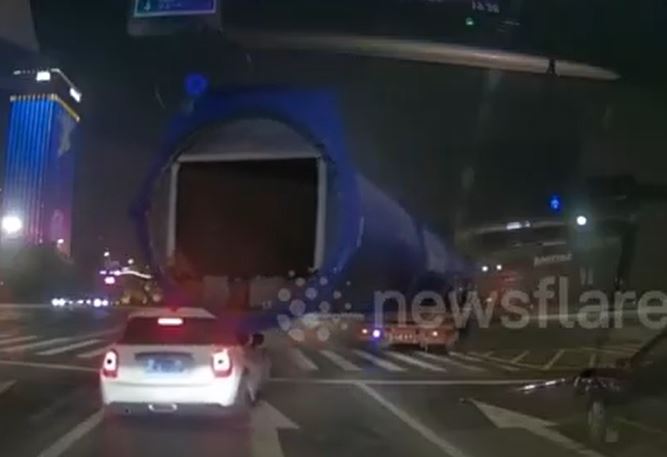 Xe tải vào cua, ống thép khổng lồ quét trúng rồi kéo lê ô tô, tài xế mở cửa thoát thân