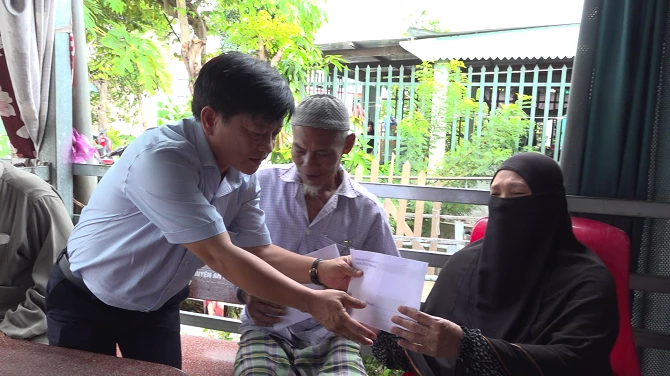 Đại diện lãnh đạo xã Vĩnh Hậu trao tiền hỗ trợ cho người dân bị 