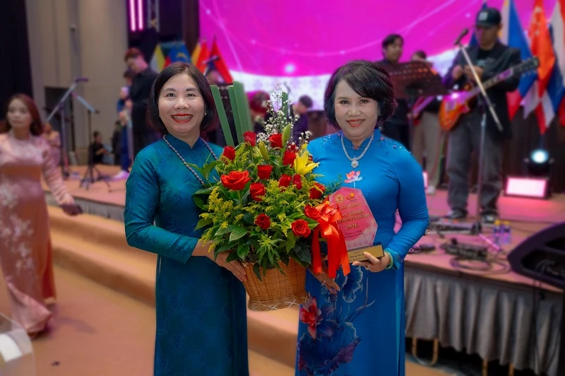 Bà Trần Thị Tú Anh - Tham tán thương mại Việt Nam tại Lào tặng hoa chúc mừng bà Đồng Thị Ánh.