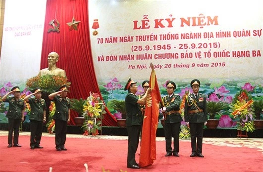 Thừa ủy quyền của Chủ tịch nước, Thượng tướng Đỗ Bá Tỵ gắn Huân chương Bảo vệ Tổ quốc hạng Ba lên Quân kỳ Quyết thắng của Cục Bản đồ.