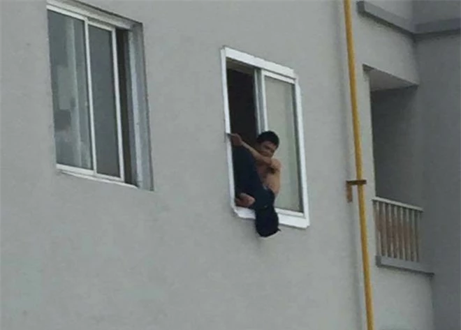 Nam thanh niên ngồi vắt vẻo trên cửa sổ tầng 21 