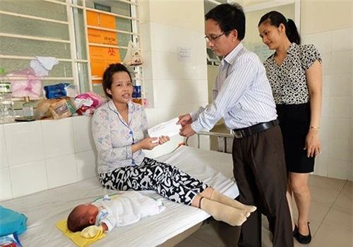 Ông Nguyễn Văn Hiền trao tặng quà cho mẹ con chị Đặng Thị Thanh Nga. Ảnh: VnExpress