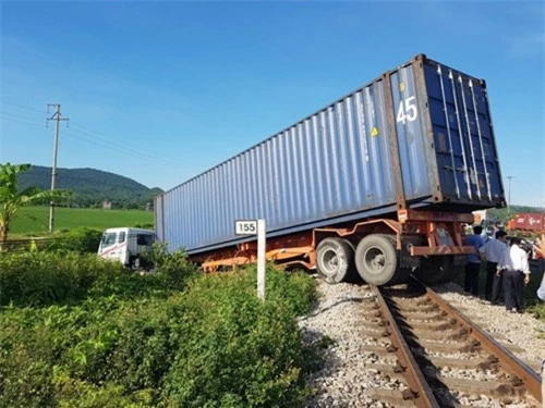 iện trường chiếc xe container nằm vắt vẻo trên đường ray. Ảnh: báo Giao thông