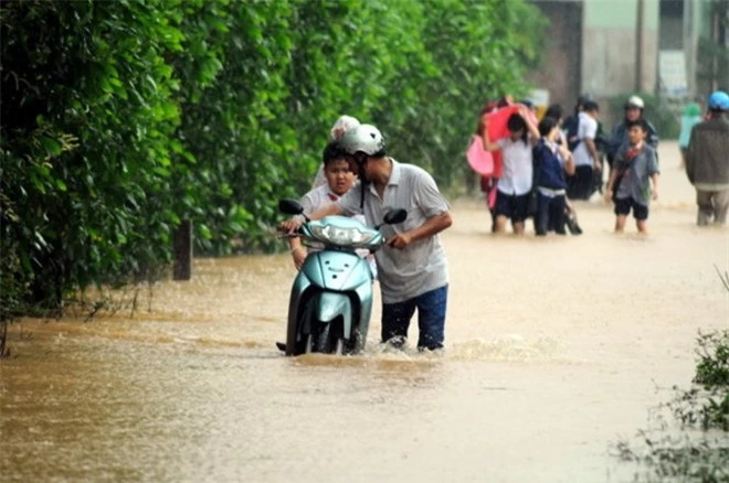 Phu huynh dắt xe đưa con đi học vì xe chết máy do ngập lụt