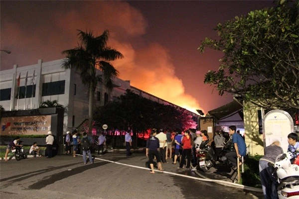 Người dân tại KCN bất lực trước đám cháy quá lớn. Ảnh báo Lao động.