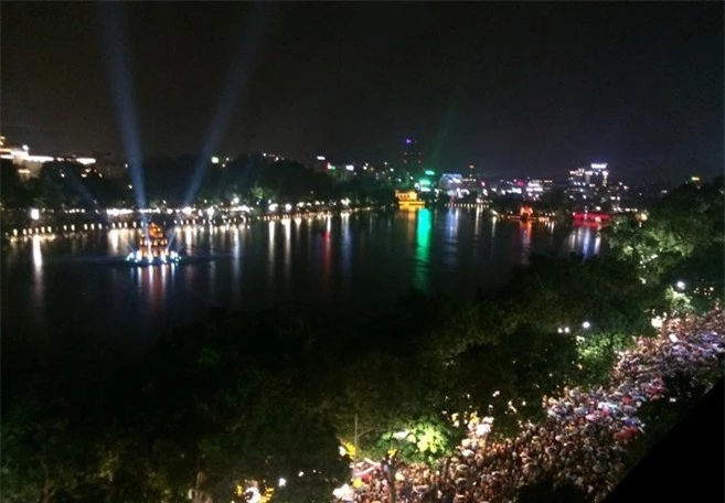 Hàng nghìn lượt người ngồi quanh bờ Hồ Hoàn Kiếm để tận mắt chứng kiến cảnh đẹp.