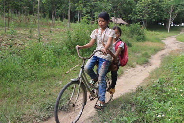 Bé Ngọc hàng ngày chở em gái đi học trên chiếc xe đạp không phanh.
