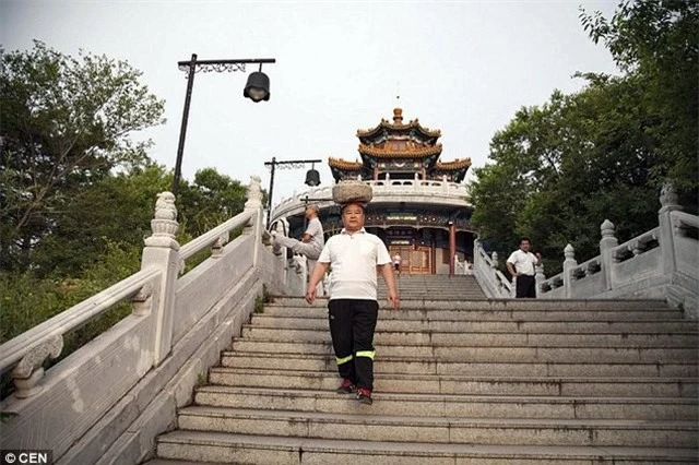 Ông Cong Yan hàng ngày đi dạo với tảng đá trên đầu.