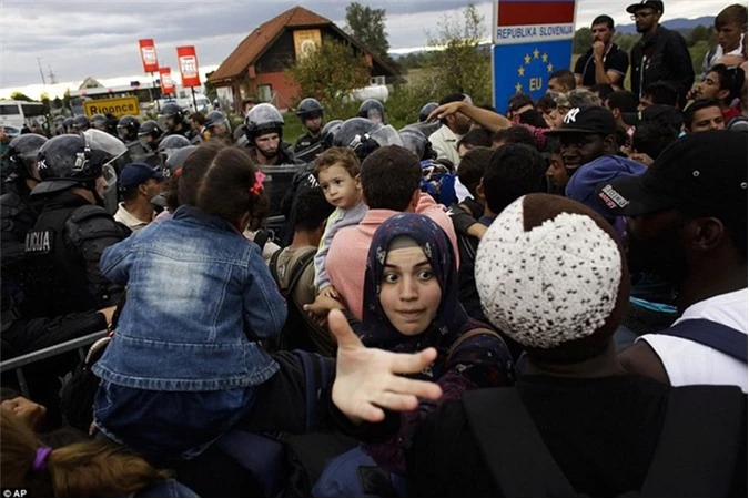 Một người phụ nữ quay người lại khi bị dòng người tị nạn đông đúc đẩy đi qua biên giới từ Croatia đến Slovenia. 