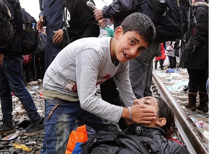 Một cậu bé khóc thảm thiết cầu xin giúp đỡ khi mẹ của cậu ngất xỉu vì bị dòng người di cư đè nát trong lúc đang cố gắng lên chuyến tàu ở biên giới Croatia-Serbia. 