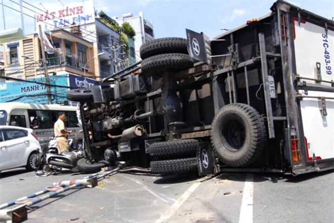 Xe tải chở bia lật trúng SH, 2 người bị thương nặng