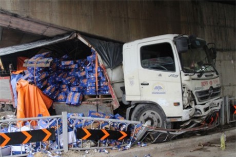 Xe tải chở hàng trăm thùng bia tông vào gầm cầu, mắc kẹt