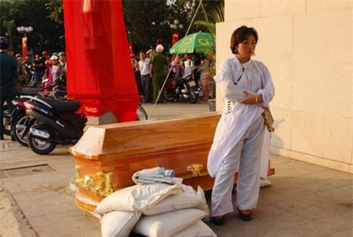 Một phụ nữ mang quan tài đặt trước cửa ngân hàng gây náo loạn