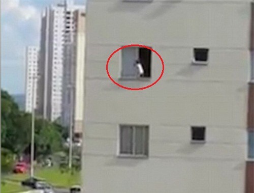 Thót tim cảnh bé trai “vui đùa” bên rìa cửa sổ nhà cao tầng