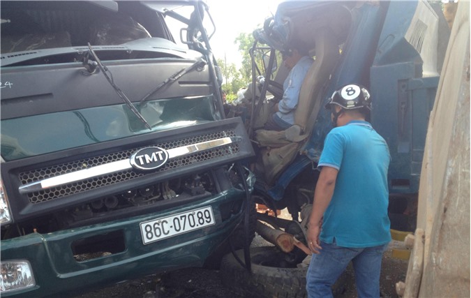 Hai xe tải đấu đầu, tài xế mắc kẹt trong cabin