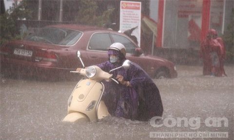 Mưa lớn, người dân Huế đẩy xuồng chở xe máy khỏi đường ngập