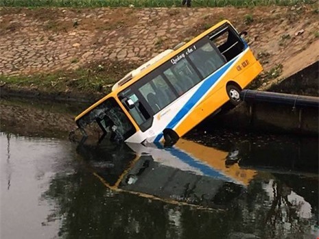 Bị xe tải chở đất tông xe buýt cắm đầu xuống kênh nước