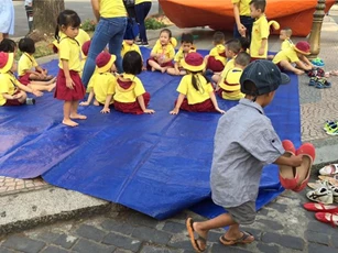 Cậu bé lượm ve chai xếp giày cho bạn được đi học miễn phí